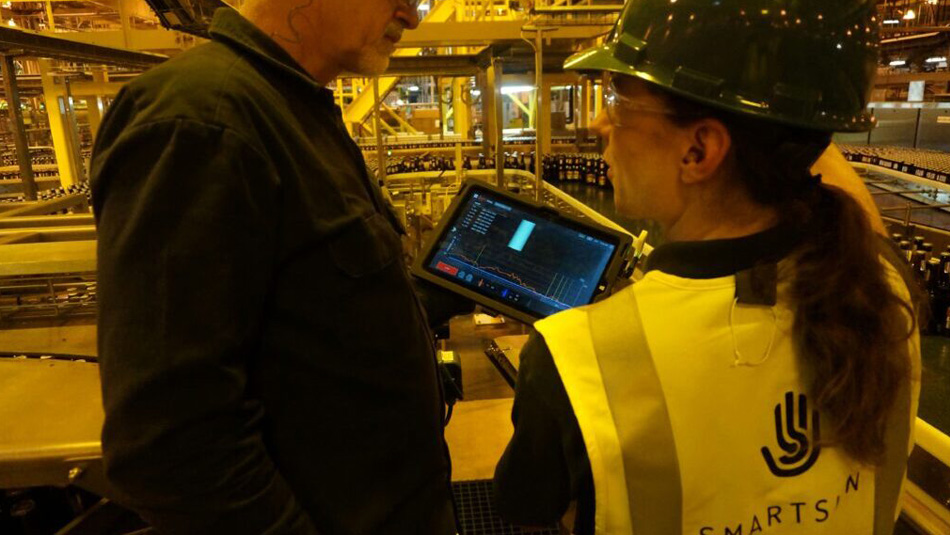 A line supervisor and a SmartSkin employee reviewing the data gathered from a beverage production line