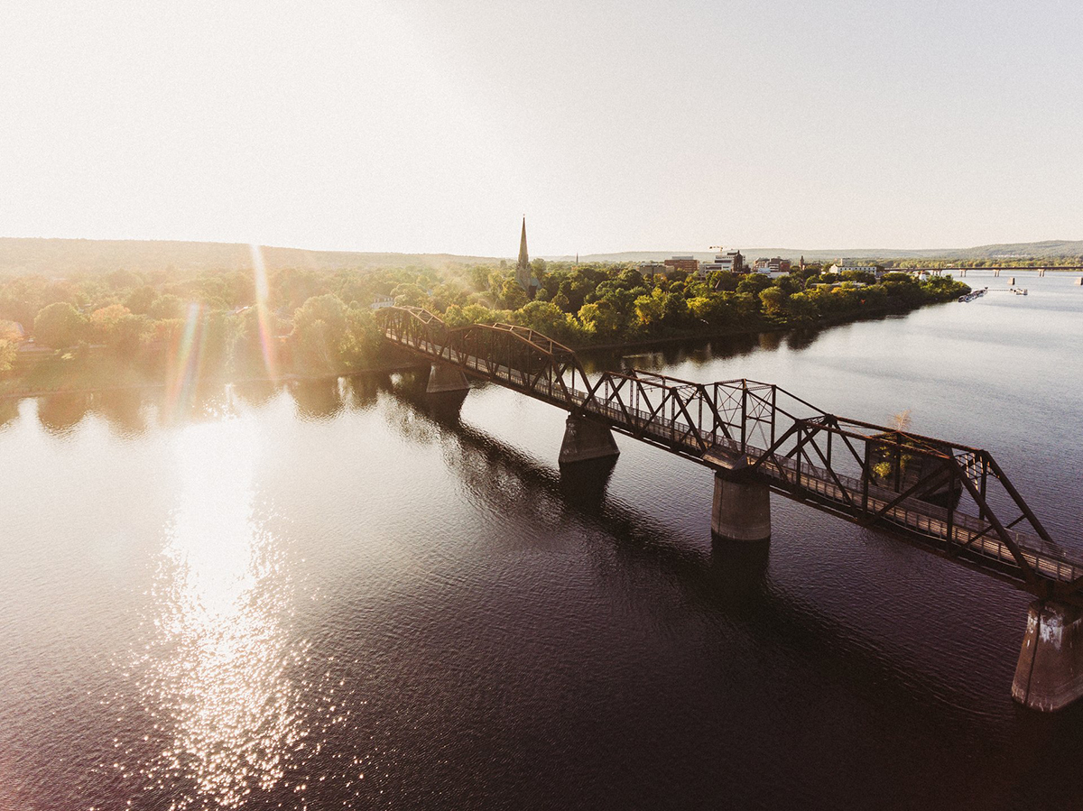 View of a river, walking bridge and downtown Fredericton area. Explore SmartSkin careers and work with us.