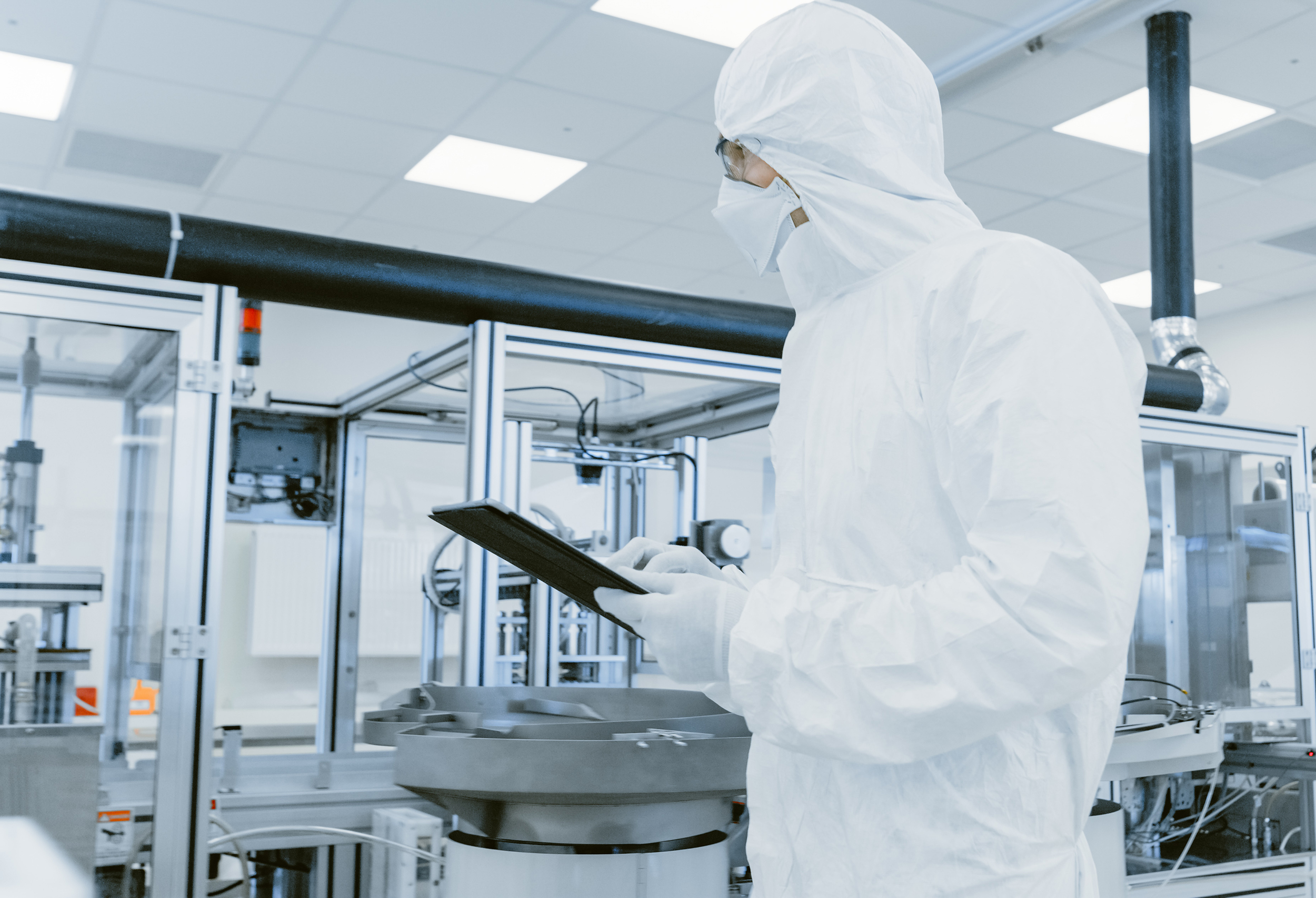 Production technician walking along a filling line holding a tablet.