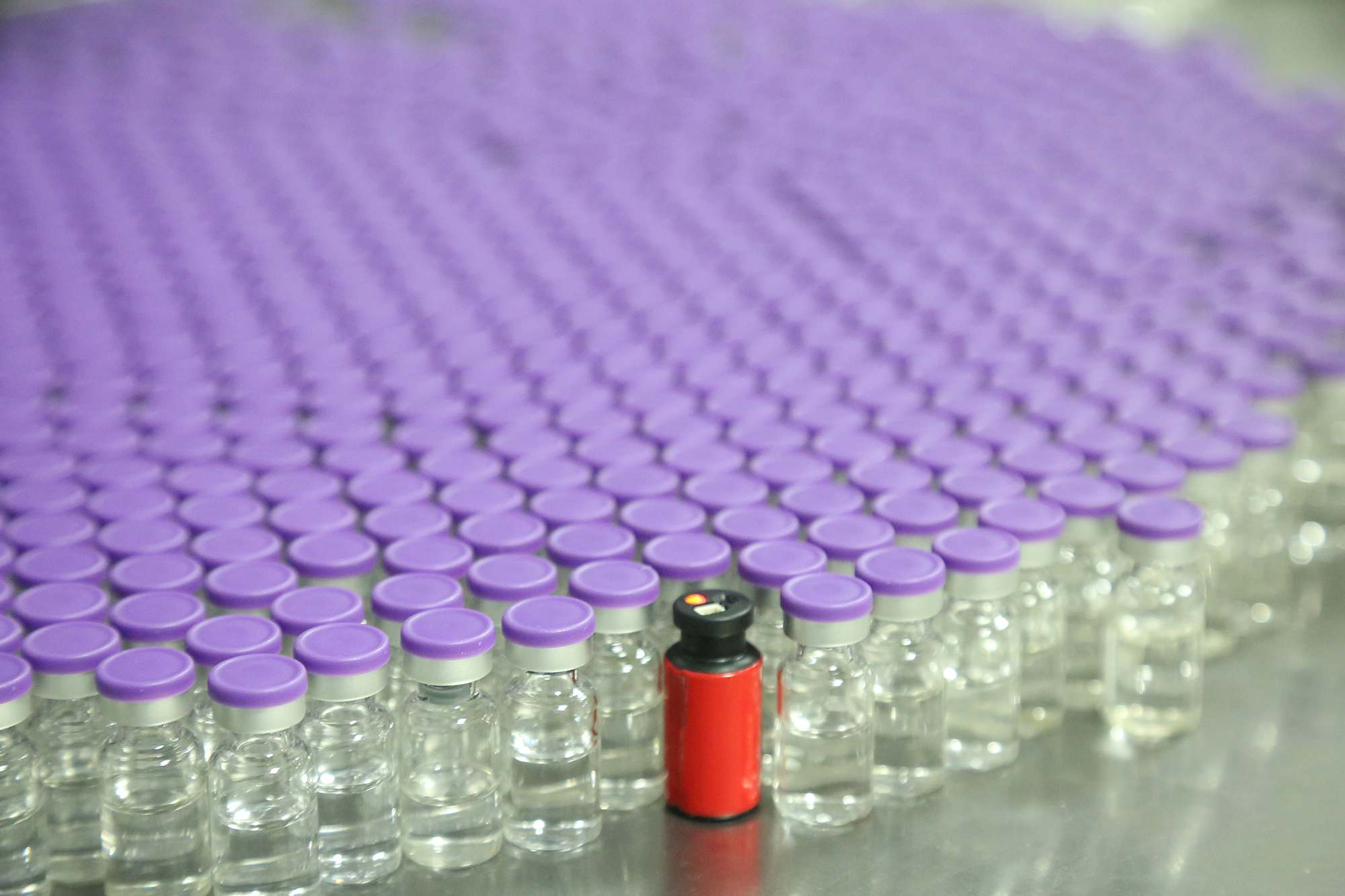 Red vial drone on pharmaceutical manufacturing line with glass vials during SmartSkin services