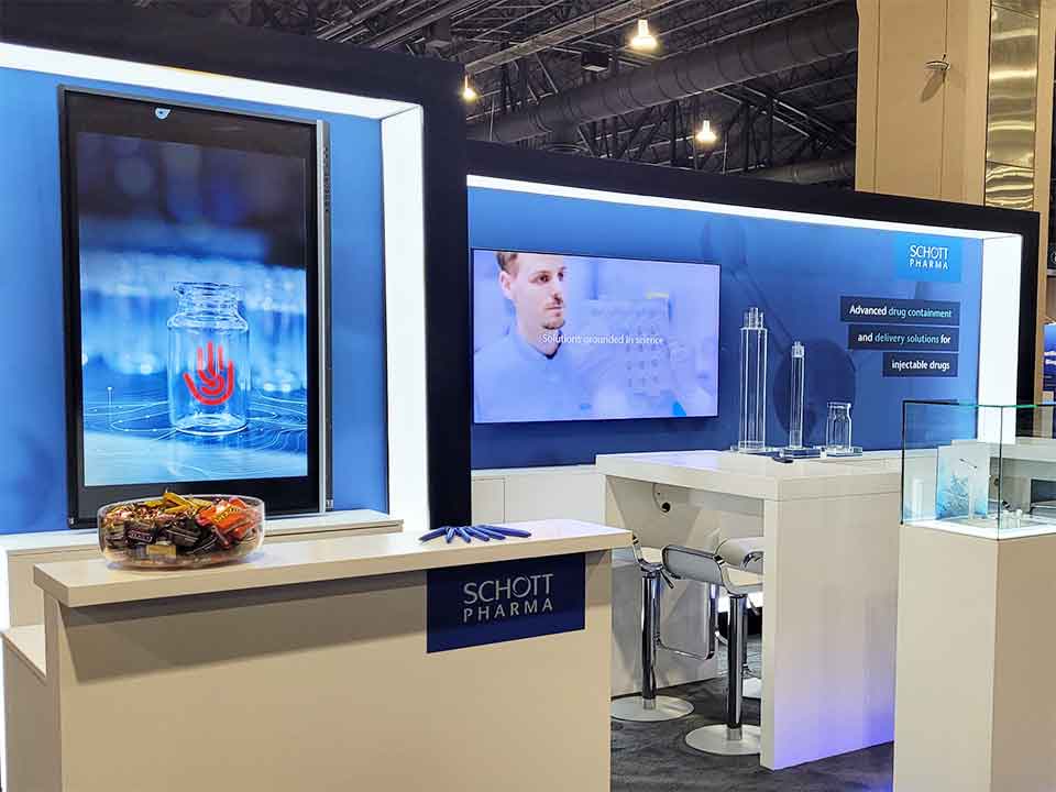 Blue Schott trade show booth with red SmartSkin logo on screen