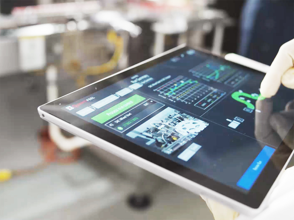 Tablet showing video footage of drone on a pharma manufacturing line and line map of pressure data